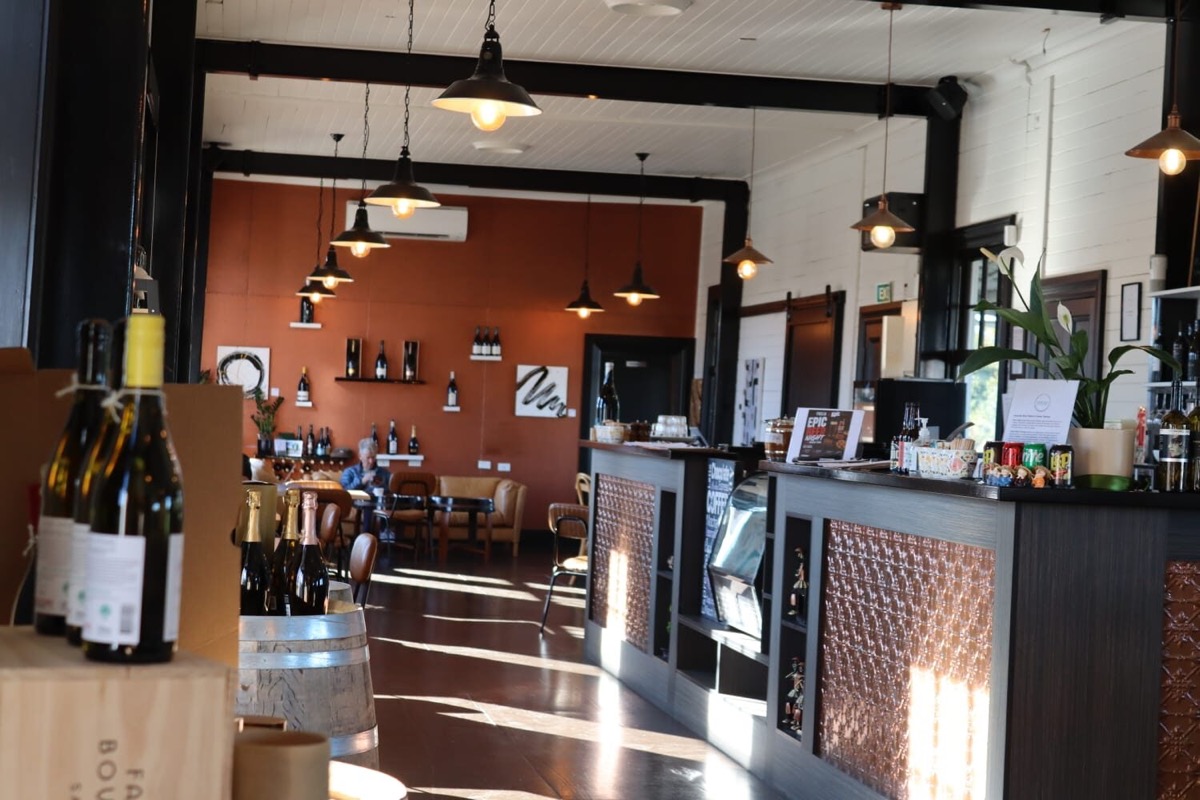 Inside Fidelio: pendant lights over the bar, bottles on the counter and the dining room beyond