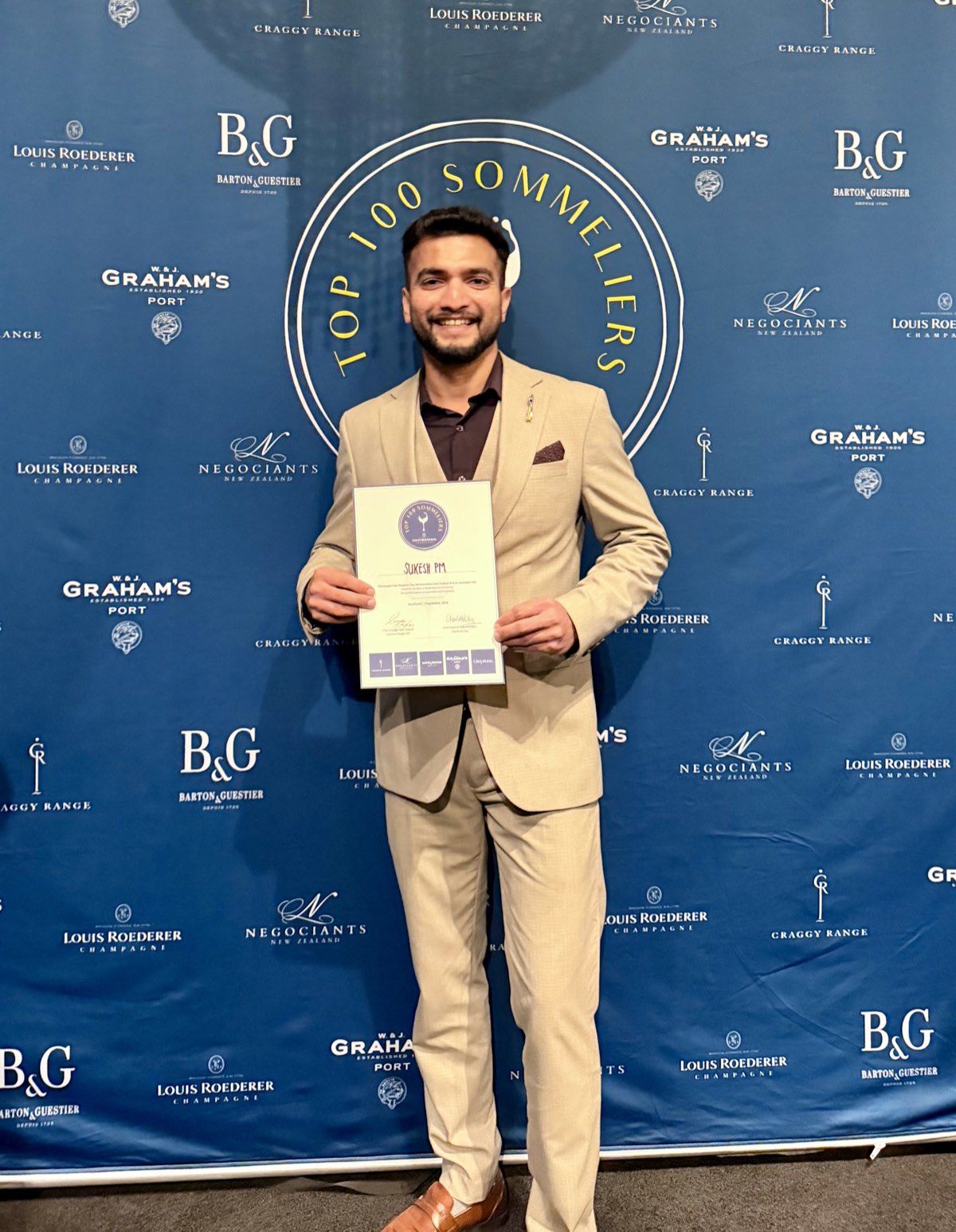 Sukesh P M holding his Top 100 Sommeliers New Zealand certificate at the Sommelier Edit awards in Auckland.