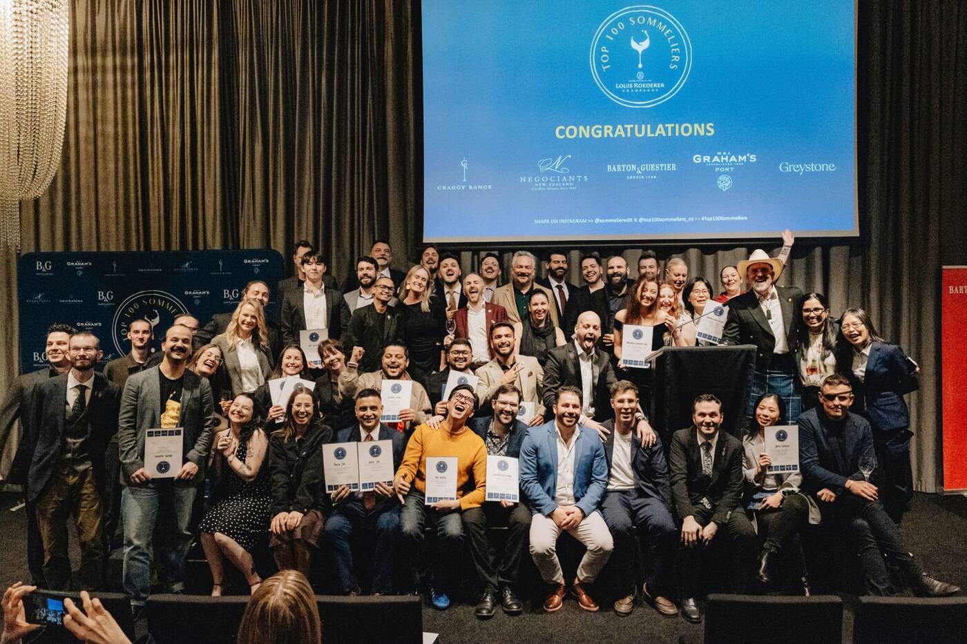 The sommeliers named in the Top 100 Sommeliers New Zealand 2026 on stage with their certificates at the awards in Auckland.
